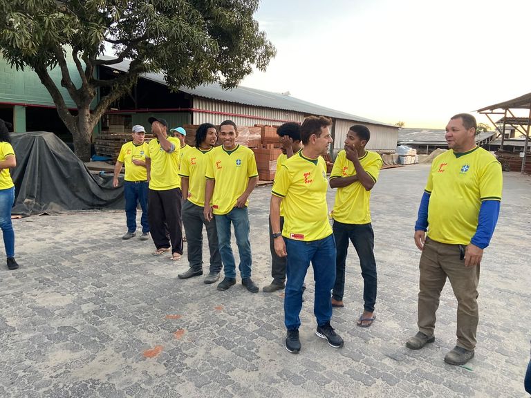 Pátio de estoque da Francischetto, com equipe conferindo materiais entre os galpões de madeira