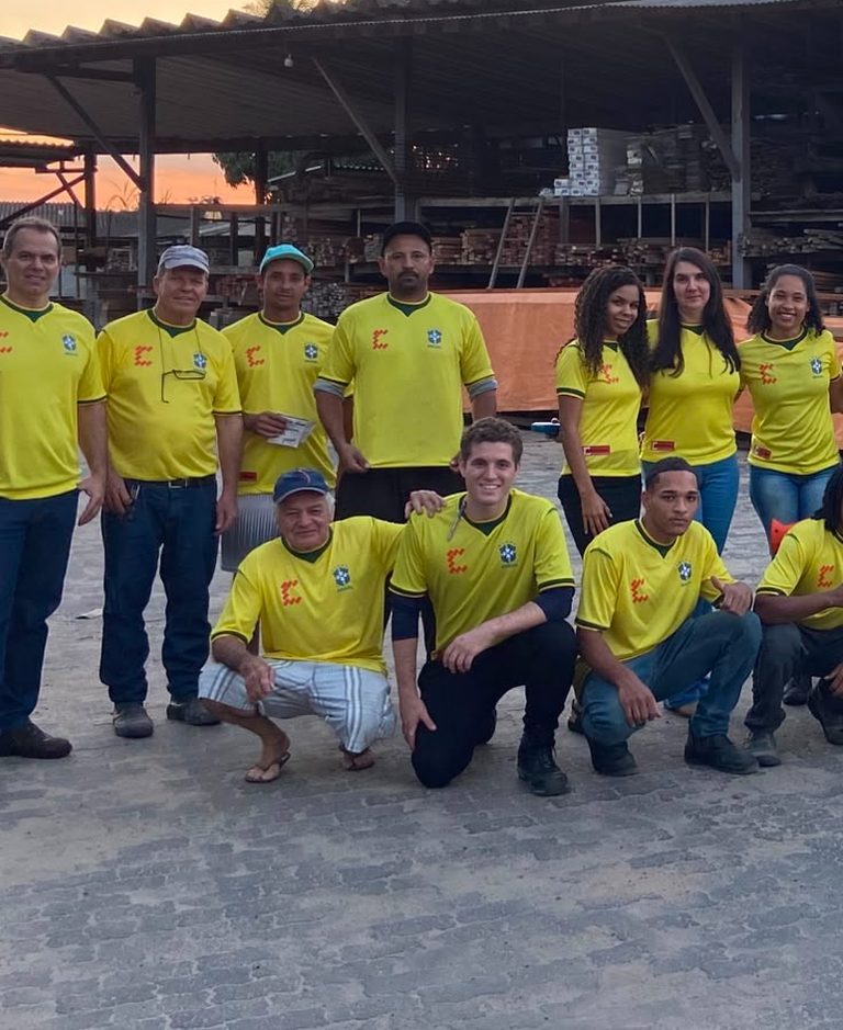 Parte da equipe Francischetto reunida no pátio da madeireira ao entardecer